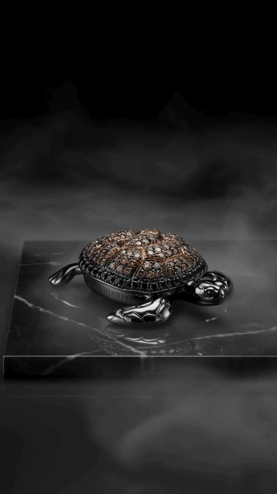 A hand-set jeweled turtle piece resting on dark marble